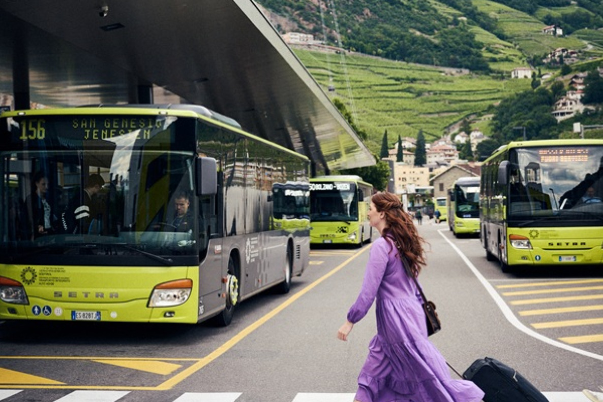 In autobus alla scoperta dell’Alto Adige Donna con trolley tra gli autobus verdi all’autostazione di Bolzano