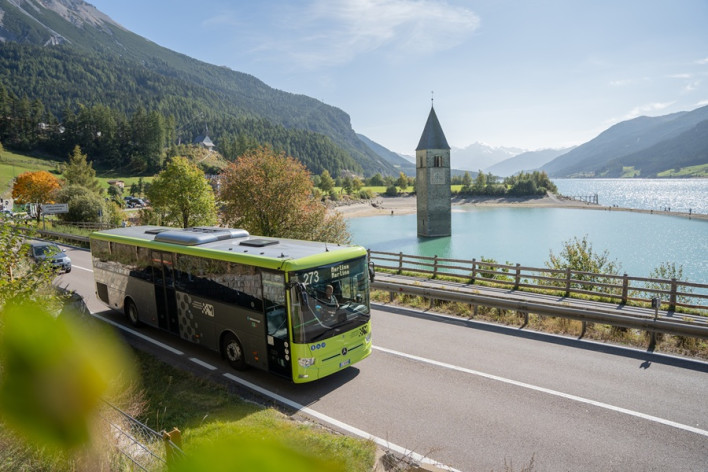 In autobus al Lago di Resia Autobus di linea lungo il Lago di Resia, con il campanile nell’acqua e le montagne sullo sfondo